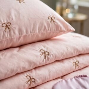 Gros plan broderie petits nœuds sur taie et housse rose poudré – HB-R22